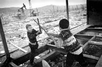 Two children, displaced from Karabakh, play in an abandoned oil field in Baku.